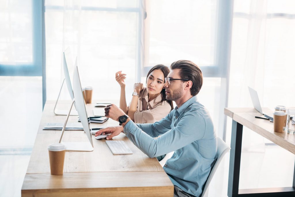 side view of interracial business colleagues working on project together at workplace in office