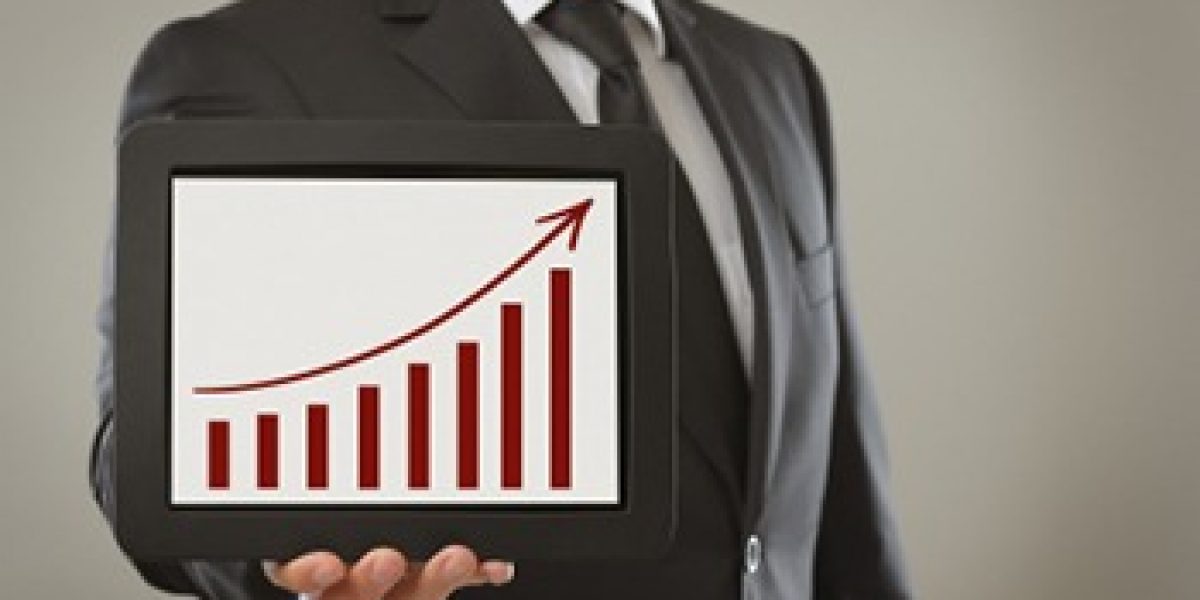 person in suit holding a tablet showing a bar chart with an increasing trendline